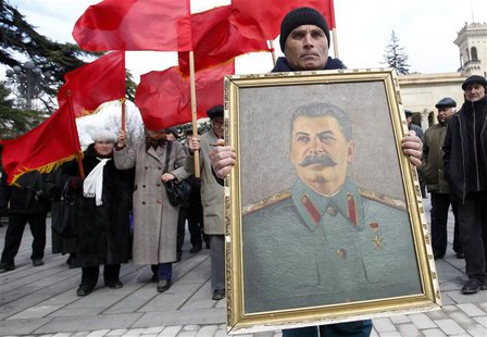 People carry red flags and a portrait of the late Soviet leader Josef Stalin during a ceremony to mark the 60th anniversary of his death in People carry red flags and a portrait of the late Soviet leader Josef Stalin during a ceremony to mark the 60th anniversary of his death in