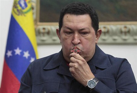 Venezuela's President Hugo Chavez kisses a crucifix as he speaks during a national broadcast at Miraflores Palace in Caracas in this Decembe Venezuela's President Hugo Chavez kisses a crucifix as he speaks during a national broadcast at Miraflores Palace in Caracas in this Decembe
