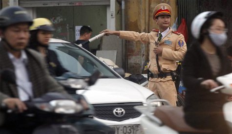 A policeman directs traffic on a street in Hanoi March 6, 2013. REUTERS/Kham A policeman directs traffic on a street in Hanoi March 6, 2013. REUTERS/Kham