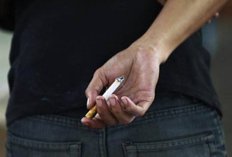 An Indonesian youth holds a cigarette while waiting for a train in Jakarta May 24, 2012. REUTERS/Beawiharta An Indonesian youth holds a cigarette while waiting for a train in Jakarta May 24, 2012. REUTERS/Beawiharta