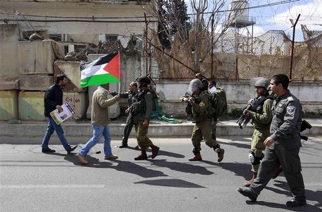 Israeli soldiers and border police walk towards Palestinian demonstrators (L) during a protest calling for the release of Palestinian prison Israeli soldiers and border police walk towards Palestinian demonstrators (L) during a protest calling for the release of Palestinian prison