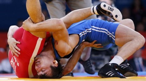 Kazakhstan's Akzhurek Tanatarov (in blue) fights with Turkey's Ramazan Sahin for the bronze medal of the Men's 66Kg Freestyle wrestling at t Kazakhstan's Akzhurek Tanatarov (in blue) fights with Turkey's Ramazan Sahin for the bronze medal of the Men's 66Kg Freestyle wrestling at t