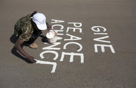 An artist known as solo7 paints a peace message on the tarmac in the Kibera slum in the Kenyan capital of Nairobi March 9, 2013. REUTERS/Kar An artist known as solo7 paints a peace message on the tarmac in the Kibera slum in the Kenyan capital of Nairobi March 9, 2013. REUTERS/Kar