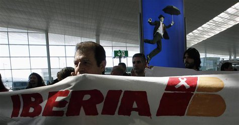A man holds a banner during an Iberia workers strike at Terminal 1 of Barcelona's airport, March 8, 2013. REUTERS/Albert Gea A man holds a banner during an Iberia workers strike at Terminal 1 of Barcelona's airport, March 8, 2013. REUTERS/Albert Gea