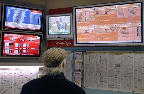 A man watches television screens in a Ladbrokes bookmaker in London February 19, 2009. REUTERS/Luke MacGregor A man watches television screens in a Ladbrokes bookmaker in London February 19, 2009. REUTERS/Luke MacGregor