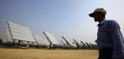 A worker walks past panels at a high-concentration photovoltaic (HCPV) solar energy power plant in Lujhu Township of Kaohsiung County, south A worker walks past panels at a high-concentration photovoltaic (HCPV) solar energy power plant in Lujhu Township of Kaohsiung County, south