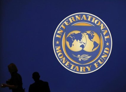 Visitors are silhouetted against the logo of the International Monetary Fund at the main venue for the IMF and World Bank annual meeting in Visitors are silhouetted against the logo of the International Monetary Fund at the main venue for the IMF and World Bank annual meeting in