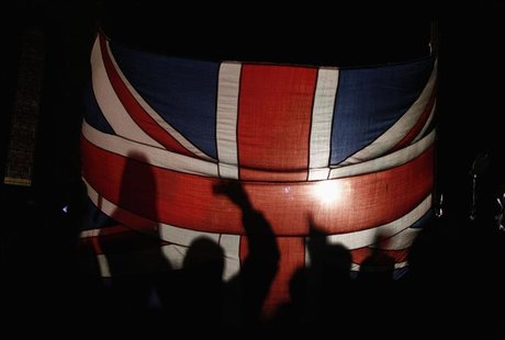 Falkland islanders are silhouetted behind the Union Jack as they react after hearing the results of the referendum in Stanley March 11, 2013 Falkland islanders are silhouetted behind the Union Jack as they react after hearing the results of the referendum in Stanley March 11, 2013