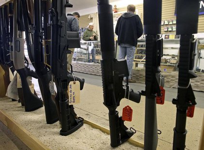 Customers are seen shopping for handguns through a rack of assault rifles at the Guns-R-Us gun shop in Phoenix, Arizona, December 20, 2012. Customers are seen shopping for handguns through a rack of assault rifles at the Guns-R-Us gun shop in Phoenix, Arizona, December 20, 2012.