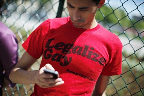 A man checks his mobile phone as civil unions supporters rally in downtown Denver before the Colorado House Judiciary Committee hearing on t A man checks his mobile phone as civil unions supporters rally in downtown Denver before the Colorado House Judiciary Committee hearing on t