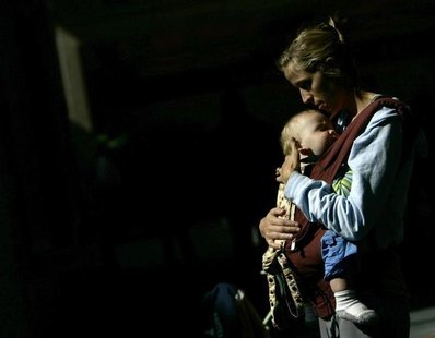 A nursing mother holds her son in front of the Delta airlines counter during a protest at Fort Lauderdale airport, Florida November 21, 2006 A nursing mother holds her son in front of the Delta airlines counter during a protest at Fort Lauderdale airport, Florida November 21, 2006