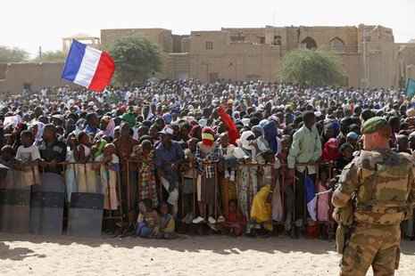 A French flag is seen as people gather to greet French President Francois Hollande during his two-hour-long visit to Timbuktu February 2, 20 A French flag is seen as people gather to greet French President Francois Hollande during his two-hour-long visit to Timbuktu February 2, 20