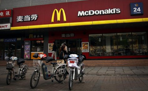 A woman walks past electric bikes sitting outside a McDonalds fast-food outlet in central Beijing March 20, 2012. REUTERS/David Gray A woman walks past electric bikes sitting outside a McDonalds fast-food outlet in central Beijing March 20, 2012. REUTERS/David Gray
