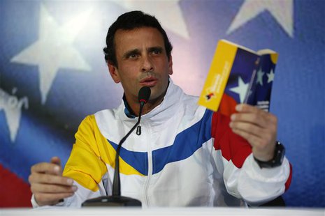 Venezuela's opposition leader and presidential candidate Henrique Capriles shows the Venezuelan constitution during a news conference in Car Venezuela's opposition leader and presidential candidate Henrique Capriles shows the Venezuelan constitution during a news conference in Car