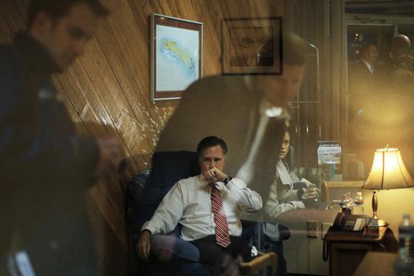 Staff members reflected off the window of the room where Republican presidential nominee Mitt Romney works before a campaign rally in North Staff members reflected off the window of the room where Republican presidential nominee Mitt Romney works before a campaign rally in North