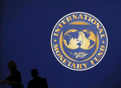 Visitors are silhouetted against the logo of the International Monetary Fund at the main venue for the IMF and World Bank annual meeting in Visitors are silhouetted against the logo of the International Monetary Fund at the main venue for the IMF and World Bank annual meeting in
