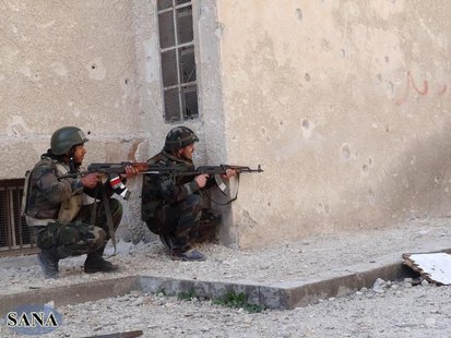 Members of forces loyal to Syria's President Bashar al-Assad are seen with their weapons at Darya near Damascus, in this handout photograph Members of forces loyal to Syria's President Bashar al-Assad are seen with their weapons at Darya near Damascus, in this handout photograph