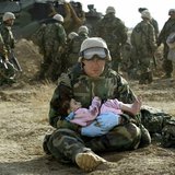 U.S. Navy Hospital Corpsman HM1 Richard Barnett, assigned to the 1st Marine Division, holds an Iraqi child in central Iraq in this March 29, U.S. Navy Hospital Corpsman HM1 Richard Barnett, assigned to the 1st Marine Division, holds an Iraqi child in central Iraq in this March 29,