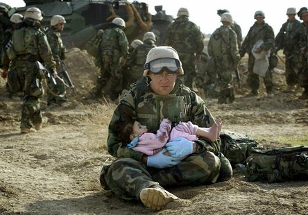 U.S. Navy Hospital Corpsman HM1 Richard Barnett, assigned to the 1st Marine Division, holds an Iraqi child in central Iraq in this March 29, U.S. Navy Hospital Corpsman HM1 Richard Barnett, assigned to the 1st Marine Division, holds an Iraqi child in central Iraq in this March 29,