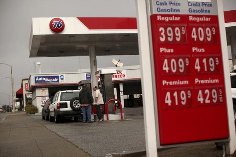 Customers fill their tanks with gasoline at an automobile service station as prices are displayed on a signboard in San Bruno, California Fe Customers fill their tanks with gasoline at an automobile service station as prices are displayed on a signboard in San Bruno, California Fe