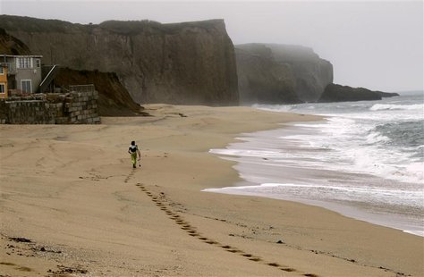 Surfer Joao Demacedo heads to a surfing spot at Martin's Beach, a popular surfing and fishing spot, in Half Moon Bay, California March 14, 2 Surfer Joao Demacedo heads to a surfing spot at Martin's Beach, a popular surfing and fishing spot, in Half Moon Bay, California March 14, 2