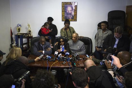 Carol Gray (centre L) shows a photograph of her late son Kimani Gray, who was killed in a New York Police Department shooting, next to City Carol Gray (centre L) shows a photograph of her late son Kimani Gray, who was killed in a New York Police Department shooting, next to City