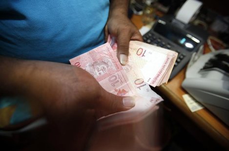 A money changer counts Malaysia's ringgit notes in Kuala Lumpur January 29, 2013. REUTERS/Bazuki Muhammad A money changer counts Malaysia's ringgit notes in Kuala Lumpur January 29, 2013. REUTERS/Bazuki Muhammad