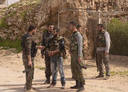 Soldiers loyal to Syria's President Bashar al-Assad talk as they hold their weapons in Khan al-Assal area, near Aleppo city March 12, 2013. Soldiers loyal to Syria's President Bashar al-Assad talk as they hold their weapons in Khan al-Assal area, near Aleppo city March 12, 2013.
