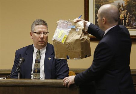 Prosecuting attorney Brian Deckert holds up a bag containing a blanket which was tested for genetic material in front of witness and Bureau Prosecuting attorney Brian Deckert holds up a bag containing a blanket which was tested for genetic material in front of witness and Bureau