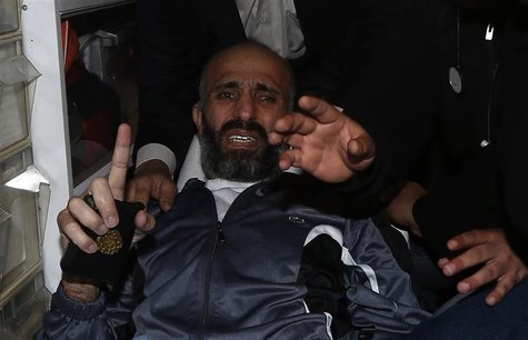 Freed Palestinian prisoner Ayman Sharawneh gestures as he holds a copy of the Koran inside an ambulance upon his arrival near Erez crossing Freed Palestinian prisoner Ayman Sharawneh gestures as he holds a copy of the Koran inside an ambulance upon his arrival near Erez crossing