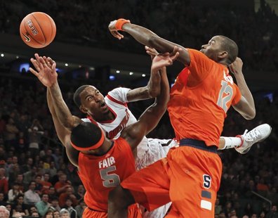 Louisville Cardinals guard Kevin Ware tries to pass the ball under pressure from Syracuse Orange forward C.J. Fair (5) and center Baye Keita Louisville Cardinals guard Kevin Ware tries to pass the ball under pressure from Syracuse Orange forward C.J. Fair (5) and center Baye Keita