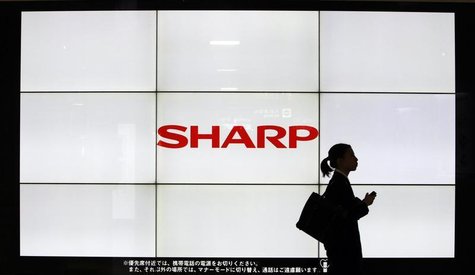 A woman walks past the Sharp Corp's Logo at a train station in Tokyo March 6, 2013. REUTERS/Yuya Shino A woman walks past the Sharp Corp's Logo at a train station in Tokyo March 6, 2013. REUTERS/Yuya Shino