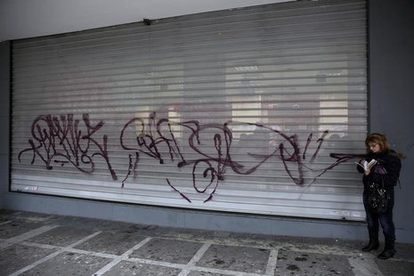 A woman checks documents outside an unemployment bureau in Athens March 7, 2013. REUTERS/Yorgos Karahalis A woman checks documents outside an unemployment bureau in Athens March 7, 2013. REUTERS/Yorgos Karahalis