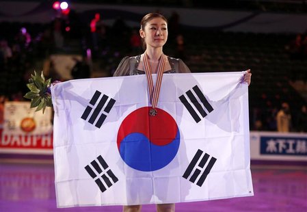 Kim Yuna of Korea poses with her gold medal and the South Korean flag after the ladies free skating at the ISU World Figure Skating Champion Kim Yuna of Korea poses with her gold medal and the South Korean flag after the ladies free skating at the ISU World Figure Skating Champion