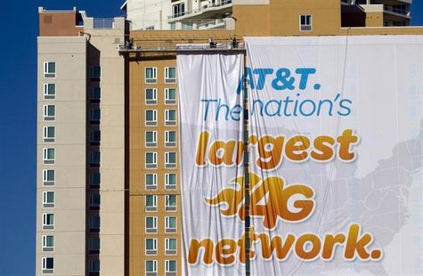 Workers put up a banner advertisement for AT&T on the side of a hotel as they prepare for International CES show in Las Vegas, Nevada Januar Workers put up a banner advertisement for AT&T on the side of a hotel as they prepare for International CES show in Las Vegas, Nevada Januar