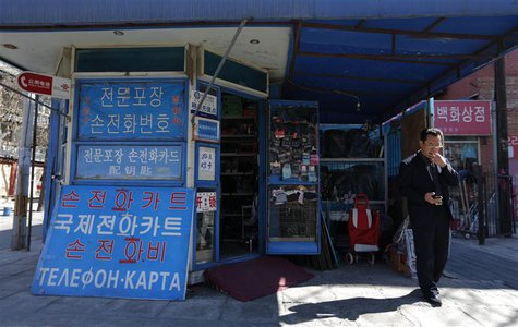 A North Korean uses a mobile phone next to a shop with a signboard written in Korean characters near the North Korean embassy in Beijing Mar A North Korean uses a mobile phone next to a shop with a signboard written in Korean characters near the North Korean embassy in Beijing Mar