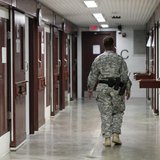 A guard walks through a cellblock inside Camp V, a prison used to house detainees at Guantanamo Bay U.S. Naval Base, March 5, 2013. REUTERS/ A guard walks through a cellblock inside Camp V, a prison used to house detainees at Guantanamo Bay U.S. Naval Base, March 5, 2013. REUTERS/