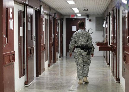 A guard walks through a cellblock inside Camp V, a prison used to house detainees at Guantanamo Bay U.S. Naval Base, March 5, 2013. REUTERS/ A guard walks through a cellblock inside Camp V, a prison used to house detainees at Guantanamo Bay U.S. Naval Base, March 5, 2013. REUTERS/