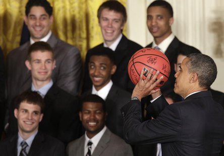 President Barack Obama holds a ball as he welcomes the University of Kentucky men's basketball team to the White House in Washington to cele President Barack Obama holds a ball as he welcomes the University of Kentucky men's basketball team to the White House in Washington to cele