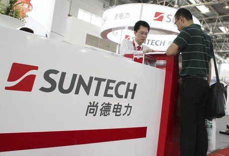 An employee (L) talks to a visitor at the Suntech booth of a photovoltaic industry exhibition in Beijing, September 5, 2012. REUTERS/Stringe An employee (L) talks to a visitor at the Suntech booth of a photovoltaic industry exhibition in Beijing, September 5, 2012. REUTERS/Stringe