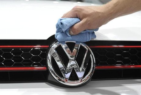 A man polishes the Volkswagen logo on a vehicle at an exhibition which is part of the annual shareholders meeting of Volkswagen AG in Hambur A man polishes the Volkswagen logo on a vehicle at an exhibition which is part of the annual shareholders meeting of Volkswagen AG in Hambur