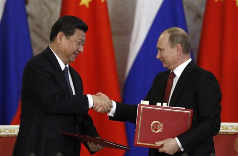 Russia's President Vladimir Putin (R) exchanges documents with his Chinese counterpart Xi Jinping during a signing ceremony at the Kremlin i Russia's President Vladimir Putin (R) exchanges documents with his Chinese counterpart Xi Jinping during a signing ceremony at the Kremlin i