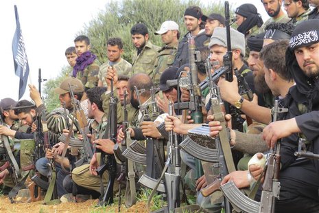 Free Syrian Army fighters carry their weapons as they sit in attention during the declaration of the formation of Al-Liwaa brigade in Binnis Free Syrian Army fighters carry their weapons as they sit in attention during the declaration of the formation of Al-Liwaa brigade in Binnis