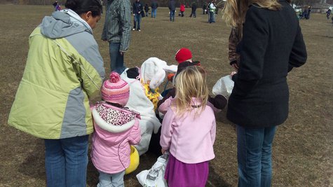 Easter Bunny stoops to help make sure child doesn't leave the field without an egg. Easter Bunny stoops to help make sure child doesn't leave the field without an egg.