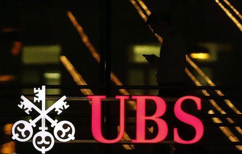 An employee uses a mobile phone as he walks past the logo of Swiss bank UBS in Zurich December 17, 2012. REUTERS/Michael Buholzer An employee uses a mobile phone as he walks past the logo of Swiss bank UBS in Zurich December 17, 2012. REUTERS/Michael Buholzer