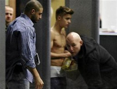Bodyguards try to block the view of Canadian singer Justin Bieber as he goes through Wladyslaw Reymont Airport in Lodz following his concert Bodyguards try to block the view of Canadian singer Justin Bieber as he goes through Wladyslaw Reymont Airport in Lodz following his concert
