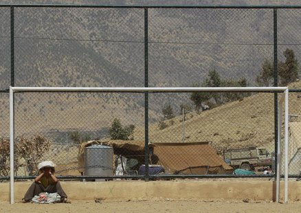 A displaced Kurd boy rests near a goalpost after receiving humanitarian aid at a refugee camp near Qandil mountain, a border zone in northea A displaced Kurd boy rests near a goalpost after receiving humanitarian aid at a refugee camp near Qandil mountain, a border zone in northea