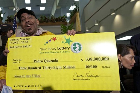 Pedro Quezada, winner of the Powerball lottery, holds up the promotional Powerball jackpot check of $338 million at the end of a news confer Pedro Quezada, winner of the Powerball lottery, holds up the promotional Powerball jackpot check of $338 million at the end of a news confer