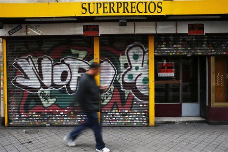 A man walks past a closed down business in Madrid March 27, 2013. REUTERS/Susana Vera A man walks past a closed down business in Madrid March 27, 2013. REUTERS/Susana Vera