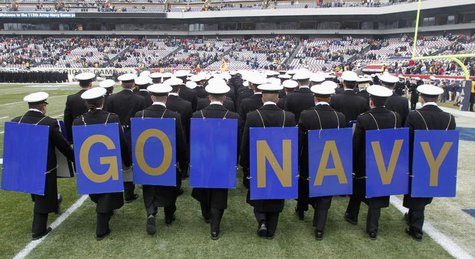 Midshipmen from the United States Naval Academy display placards on their backs as the exit field before the start of the Army versus Navy N Midshipmen from the United States Naval Academy display placards on their backs as the exit field before the start of the Army versus Navy N